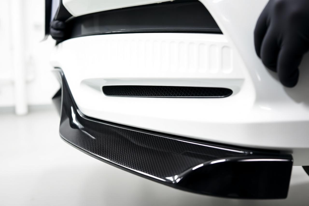 Front lip spoiler being professionally fitted in a clean workshop
